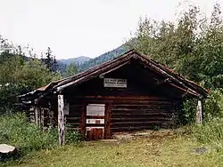 The log-built post office at Wiseman, seen here in 1995, has been sinking into the ground for the past century, and is now a couple of feet below ground.