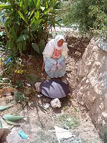 Woman in yard with iron griddle