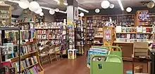 Photo of the inside of a bookstore with wooden shelving. A large "keep abortion legal sign" decorates a bookshelf.