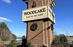 Entrance sign for Woodlake, with the Swift Creek Reservoir behind it.