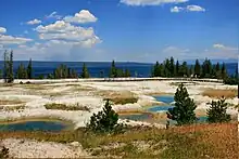 Several pools of blue water in ashen rock basin.