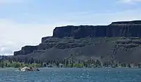 Tall dark escarpment above the lake