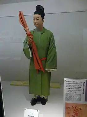 Contemporary men's dress, with green hō, white hakama, and kanmuri cap. This reconstruction is probably outdated; the hō should be shorter, with a short pleated frill beneath, as in the women's costume.