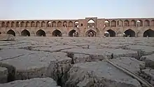 The dry Zayanderud river with Si-o-se-pol on background in 2018.