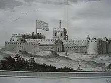 Shore-facing military fortification with two towers visible on the side walls and a central tower overlooking the fort entrance. The United Kingdom flag flutters in the wind