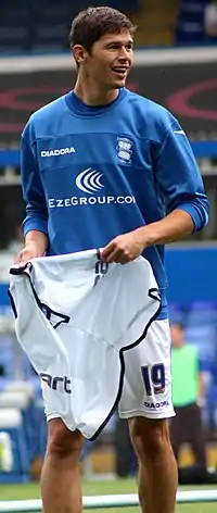 White man wearing blue and white sports training kit, pictured outdoors