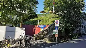 Entrance with retaining wall next to hillside with steps