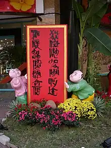 位於阮惠大路花卉展覽會中，采用左起直書的國語字書法（國語字）圖中文字為：Tân niên hạnh phúc bình an tiến新年幸福平安進Xuân nhật vinh hoa phú quý lai春日榮華富貴來