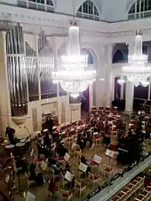 Stage with music stands and some musicians