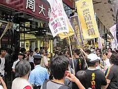 連結美孚苦主，在新鴻基旗下周大福金鋪門口抗議。2011年5月1日。