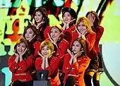 Twice performing on stage in red stage outfits