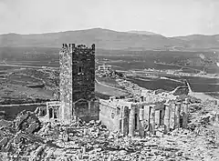 Black-and-white photograph of a tower, with the view of a city below.