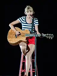 Taylor Swift strumming a guitar