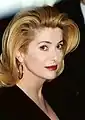 Catherine Deneuve  t the 1995 Cannes Film Festival with blonde hair and facing to the left