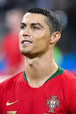 A man in a red shirt sticks out his tongue.