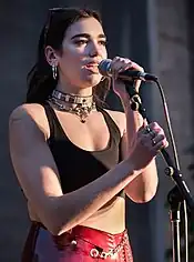 Colour photograph of Dua Lipa performing in 2017