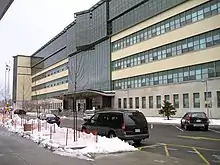  oblique view of a long, modern building about 6 storeys high, with many windows and large main entrance