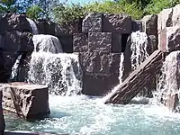 Waterfalls flowing over stone blocks into a pool