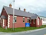 A building in red brick and a blue info panel in front