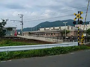 車站外觀後方棕色建築物是弘前市立石川暖水泳池