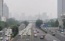 图片中间是双向六车道的跨线桥。在跨线桥两侧各有两车道的匝道桥，相比跨线桥坡度较大。远处可见南北向的桥梁。