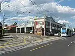 A photo of Kew tram depot. There is one C-class stabled and another C-class is passing the depot on Barkers Road.