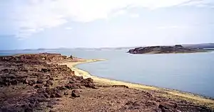 A lake with land in the foreground and background.