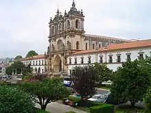 Church facade integrated into a complex of white buildings with red roofs