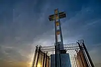 White cross on top of a hill and American flag