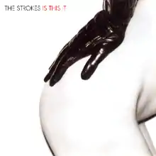 Mostly white album cover containing, largely in the right-hand side, a woman's nude right bottom and hip, with a black leather-gloved hand resting on it. It is captioned "THE STROKES IS THIS IT" in the top left-hand corner.