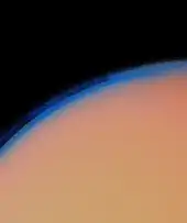 Cream-colored section of a disk is separated from the black space above by a fuzzy blue curve