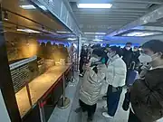 游客驻足观赏换乘通道中展示的6号线建设过程中挖掘发现的古井 (2023年2月)