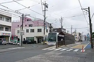 電車站全景白色2層高建築物是市內線營業處（現時已經拆毀，遷移至左邊已結業的薄餅店遺址），白色建築物前方是電車停泊線（2010年8月）