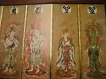 Four deities on four sections of a folding screen. Two of them are female and dressed in robes. The other two are male and only sparely dressed. All four have halos with flames.