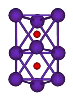 两个共面的正八面体的球棍模型。这一结构的9个顶点上的紫色球代表铷，两个八面体中心的小红球代表氧。