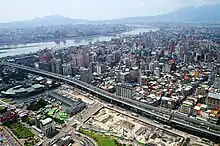 流經臺北市區的淡水河。左岸屬新北市，右岸屬臺北市。遠處左側山峰為觀音山